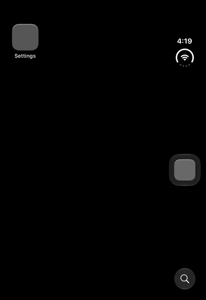 运行 iOS 27.1 beta 的 iPhone Duo 模拟器首次启动时的外屏:深色主屏幕,左上角是设置图标,右侧边缘竖向排着时钟与 Wi-Fi 状态,右边是一块 Dock 方块,右下角是搜索按钮