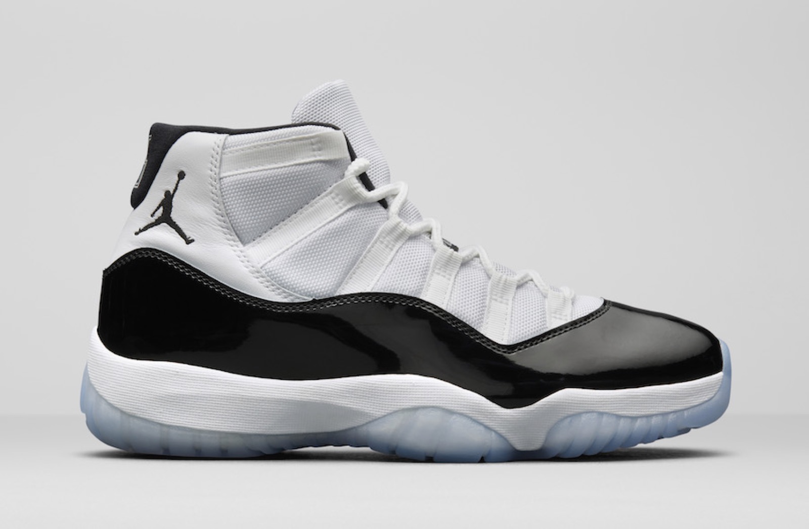 Perfil lateral do Air Jordan XI Concord, mostrando o mudguard de couro envernizado preto e a sola translúcida
