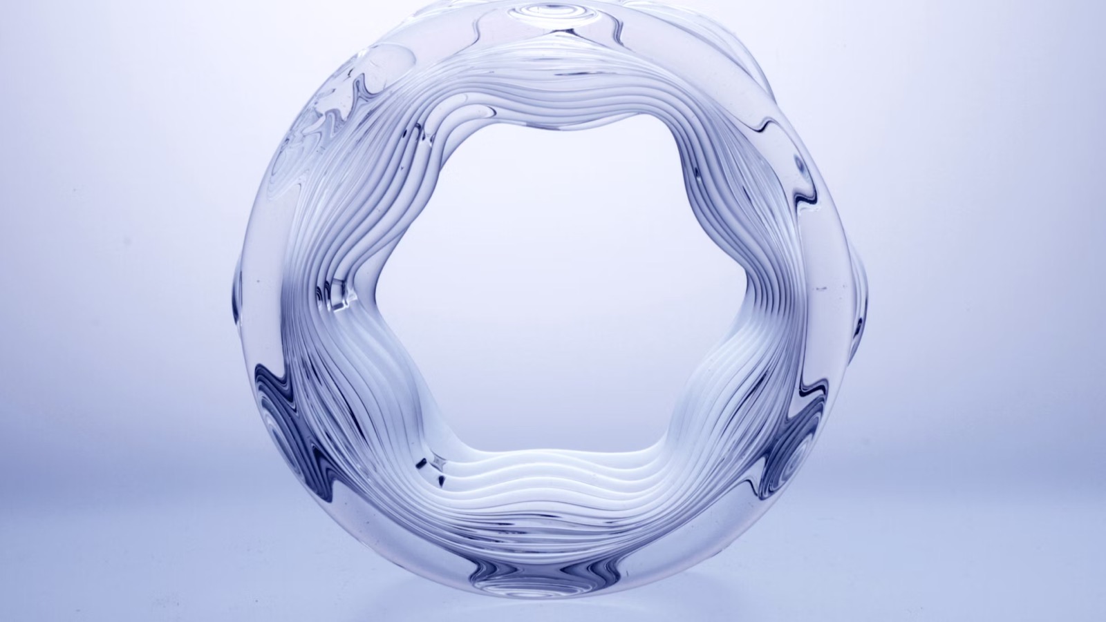 Um vaso opticamente transparente produzido pela impressora 3D G3DP de Oxman, suas paredes mostrando as ondulações em camadas do vidro fundido depositado computacionalmente