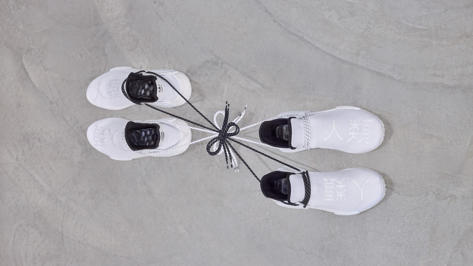Tênis Adidas Pharrell Williams NMD Hu em branco, com "Human Race" impresso nos cabedais em caracteres japoneses