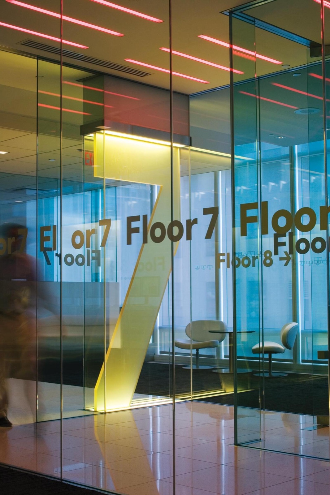 Tipografía de señalización superescala "Floor 7" en las mamparas de cristal de la sede de Bloomberg en Nueva York, diseñada por Paula Scher en Pentagram