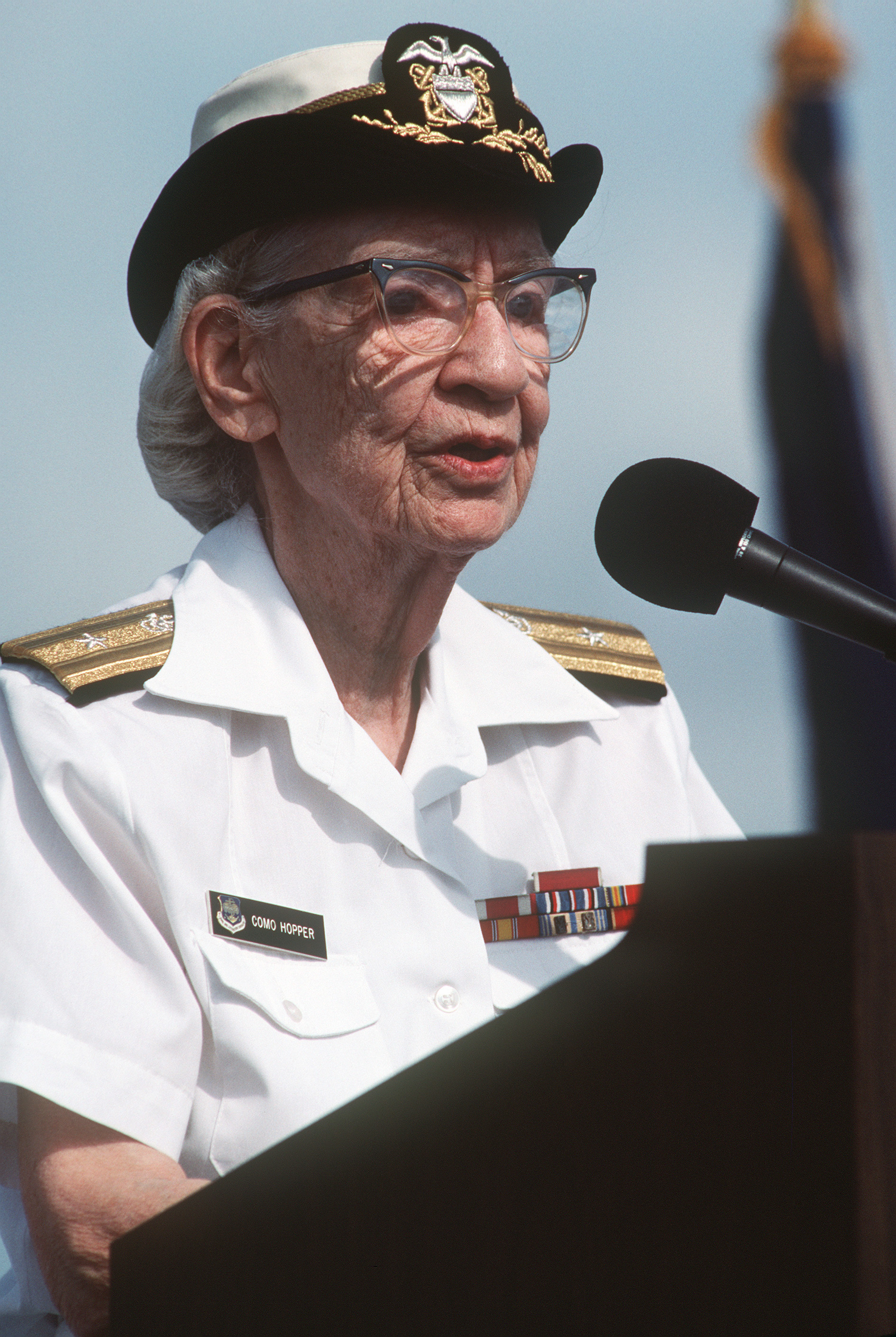 Commodore Grace Hopper speaking at a podium, 1985